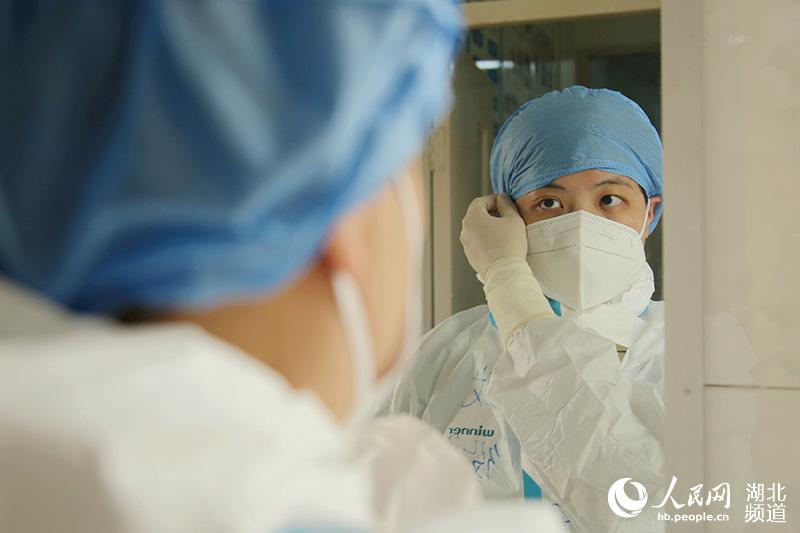 2020年3月5日，廣西支援湖北省十堰市鄖陽區抗“疫”醫療隊隊員馬玉在進入隔離病區前整理防護裝。