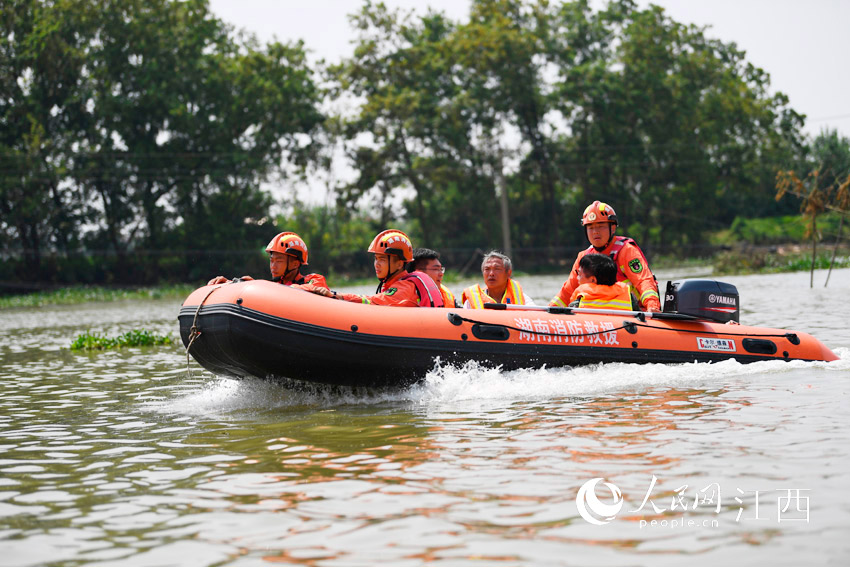 湖南郴州消防救援支队的指战员们驾着冲锋舟转移受灾群众。（人民网 时雨/摄）
