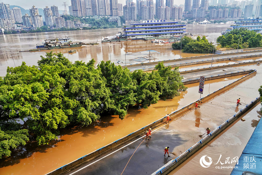 8月21日，重庆渝中区储奇门江边，环卫工人正在清扫积水。 罗嘉摄