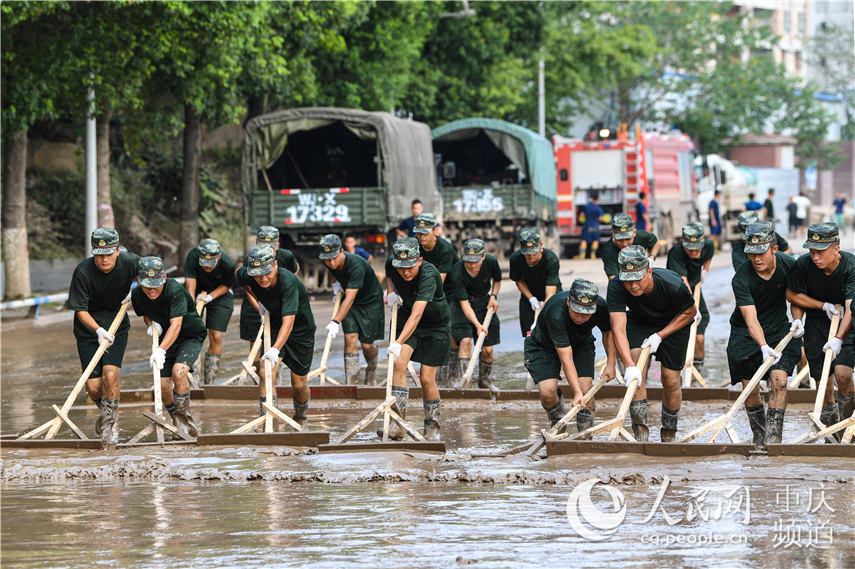 8月22日，在重庆市巴南区巴滨路，武警重庆总队机动支队官兵正在对积水和淤泥进行清理。王�Z 摄