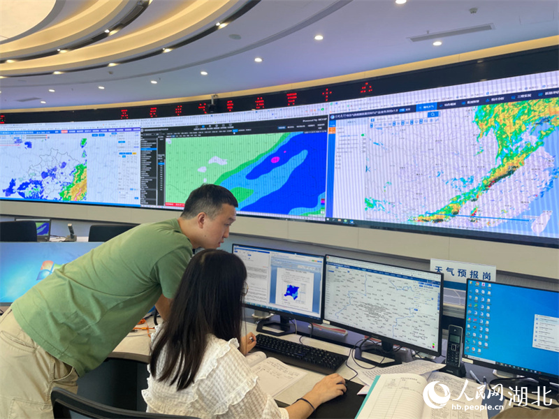 武汉市气象台预报员杨海鹏和同事一起盯紧数据变化。人民网记者 周恬摄