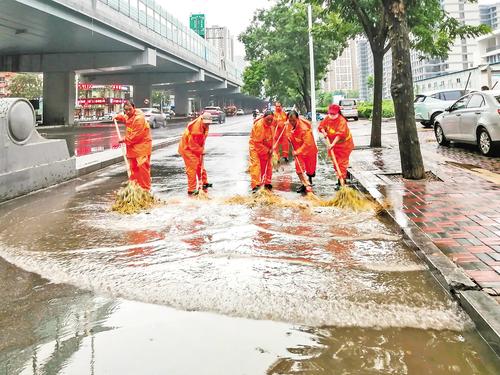 8月17日，石家庄市長安區環衛大隊的環衛工人在和平路上清理路面積水。 本報記者 田明攝