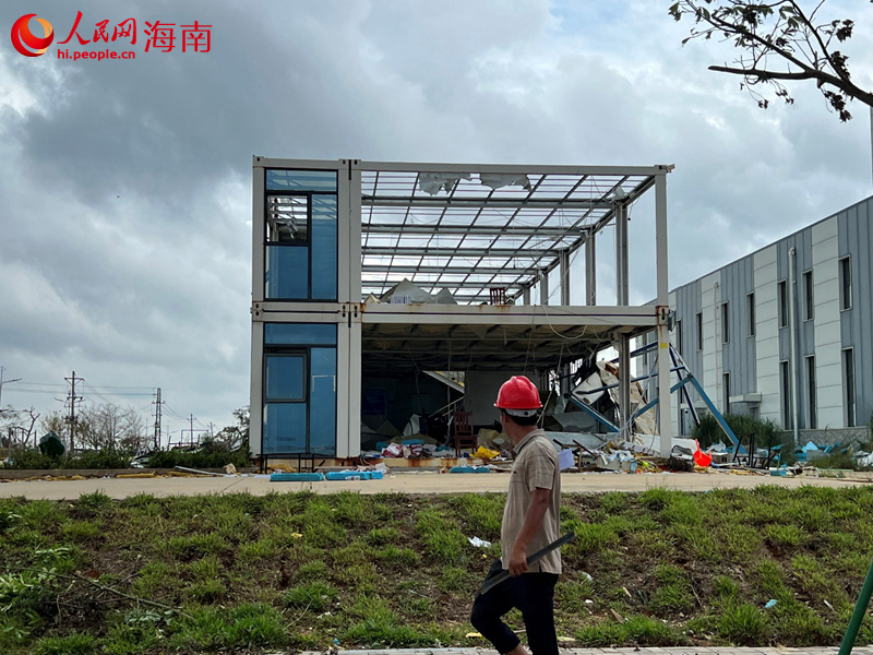 一名工人走過被台風刮的千瘡百孔的衛星總裝測試廠房項目部。人民網記者 李學山攝