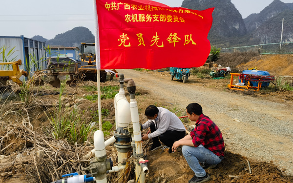 在烈日下，黨員帶頭檢查滴灌設施。周觀平攝
