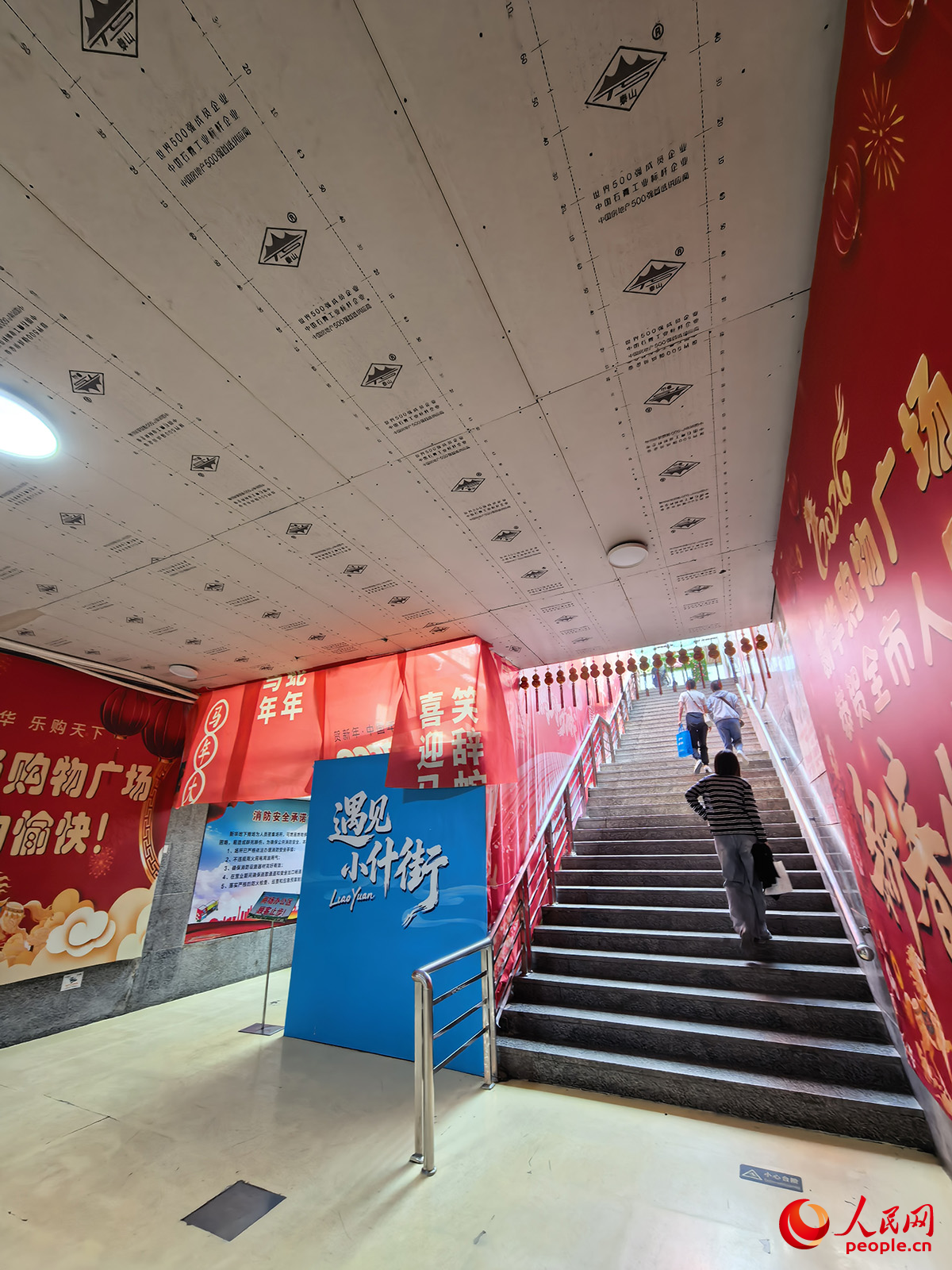 新华时尚购物广场11号门出入口处,顶部和违建处板材均为临时搭建。人民网记者李洋摄