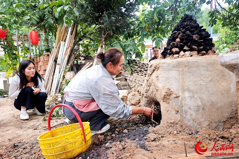 王绿瑞正在给游客制作当地美食。人民网记者 阎梦婕摄