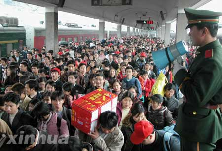 1月30日,在广州火车站第四站台出口,一名武警战士在现场维持秩序。当日,广州站到达旅客达到25万人,迎来节后返程客流最高峰。 新华社记者徐清扬摄