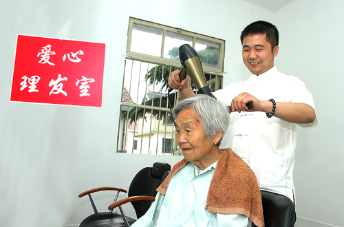5月9日上午,贺中明在爱心理发室为老人服务。